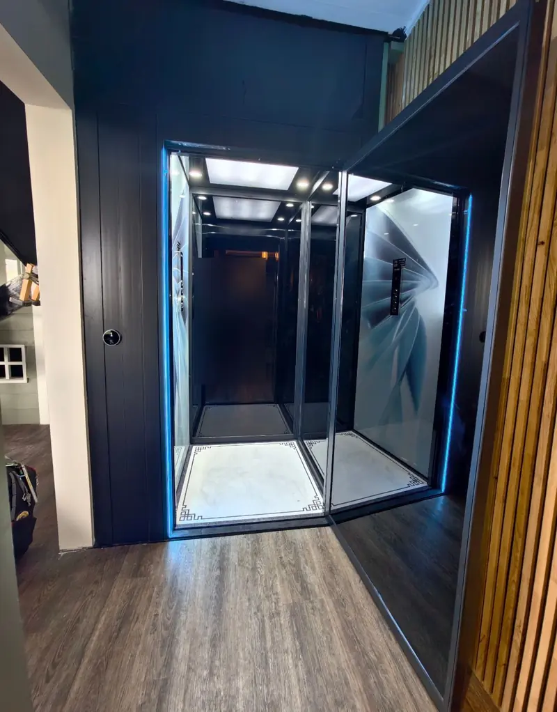 Dark glass lift cabin with blue LED edge lighting, installed by Lift Ease