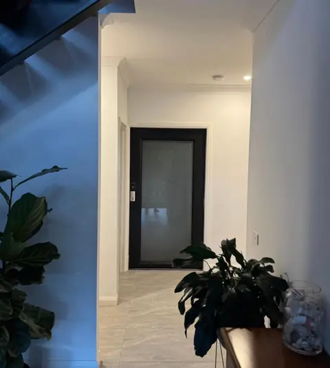 Black-framed lift door at the end of a home hallway, installed by Lift Ease