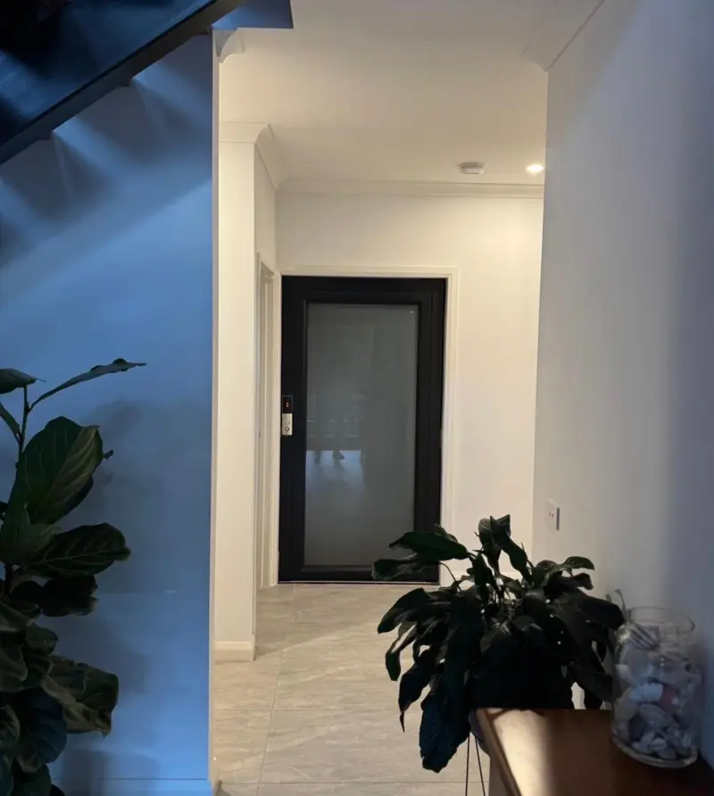 Black-framed lift door at the end of a home hallway, installed by Lift Ease