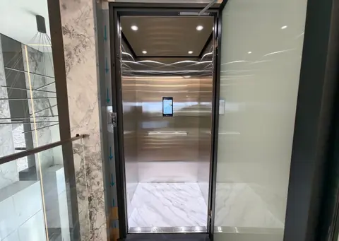 Open lift with stainless interior and marble surrounds, installed by Lift Ease