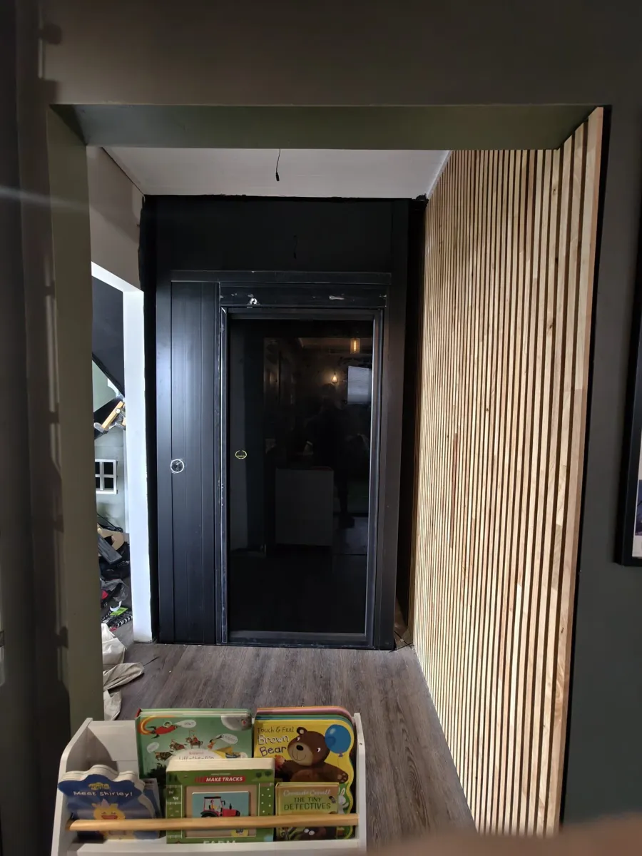 Modern home elevator entrance with black frame and wooden interior in South Yarra, Victoria